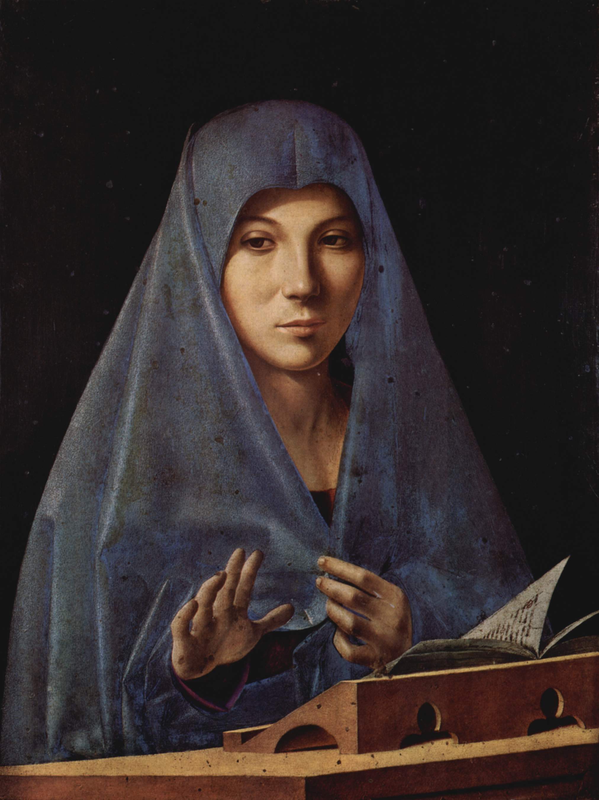Antonello da Messina’s Virgin Annunciate: Mary in a blue veil raises one hand above an open book.