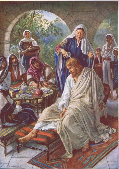 Mary Anointing Jesus by Harold Copping: a woman standing behind the seated Jesus pours perfume from a small jar onto his head while most of the guests watch. A painting of the anointing at Bethany.